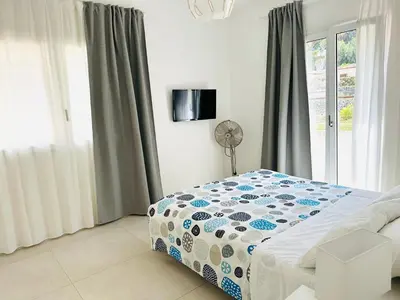 a bedroom with a bed with a blue and white comforter at Casa Battigia in Alcamo