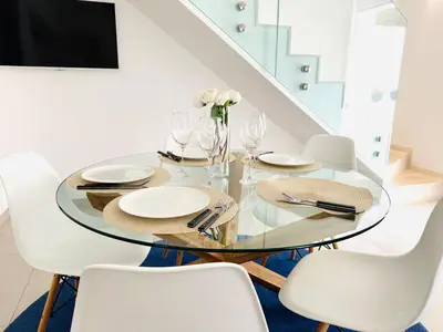 a dining room with a glass table and white chairs at Casa Battigia in Alcamo