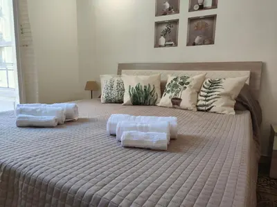 a table with white plates and a vase of white flowers at Central Station Apartaments Casa Vacanze in Palermo