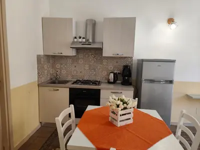 a kitchen with a table with a vase of flowers on it at Central Station Apartaments Casa Vacanze in Palermo