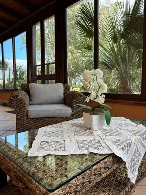 a living room with a glass table with flowers on it at Rifugio Giudeo in Balestrate