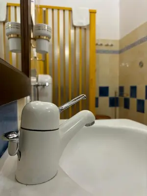 a white tea kettle sitting on a bathroom sink at Rifugio Giudeo in Balestrate