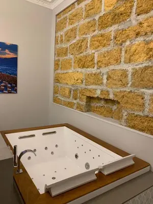 a bath tub in a bathroom with a brick wall at Romantic Suite in Palermo