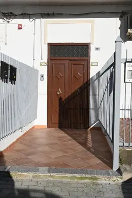 a wooden door on a building with a fence at Alla Metro in Capaci