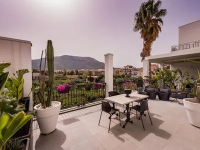 a patio with a table and chairs and plants at Apartment Wohnung dei Mori in Terrasini by Interhome in Terrasini