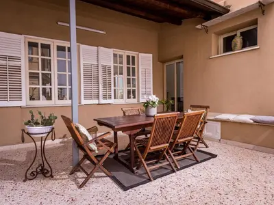 a wooden table and chairs in a patio at Apartment Wohnung dei Mori in Terrasini by Interhome in Terrasini