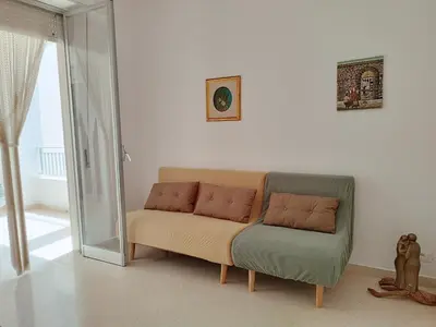 a living room with a couch and a glass door at Alessandra in Alcamo