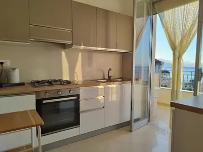 a kitchen with a stove and a sink and a window at Alessandra in Alcamo