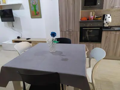 a dining room table with a vase with a blue flower at Heidi's home in Villabate