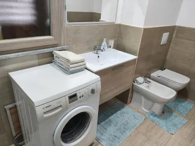 a bathroom with a washing machine and a sink at Heidi's home in Villabate