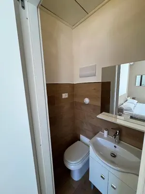 a bathroom with a toilet and a sink and a mirror at ÀSicilia Home Holiday in Palermo