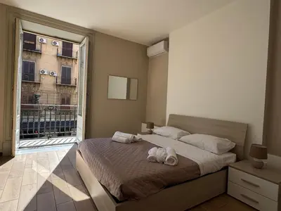a bedroom with a bed and a large window at ÀSicilia Home Holiday in Palermo