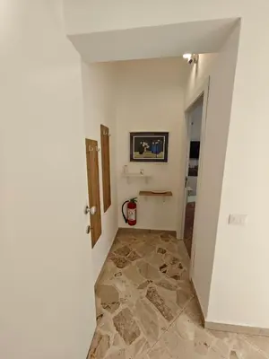 a hallway with white walls and a tile floor at Kennedy 100 in Capaci