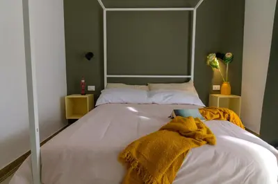 a living room with orange walls and a coat hanging on a wall at Curò in Cinisi
