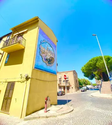 a building with a mural on the side of it at La Casa del Sole in Corleone