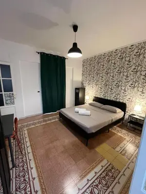 a bedroom with a bed and a green curtain at Villareale28 suite in Palermo
