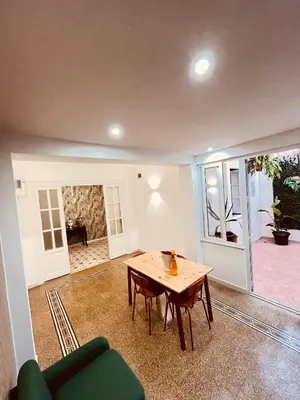 a living room with a table and a green couch at Villareale28 suite in Palermo