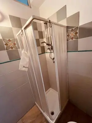 a shower with a glass door in a bathroom at Villareale28 suite in Palermo