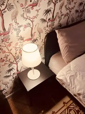 a lamp on a night stand next to a bed at Villareale28 suite in Palermo