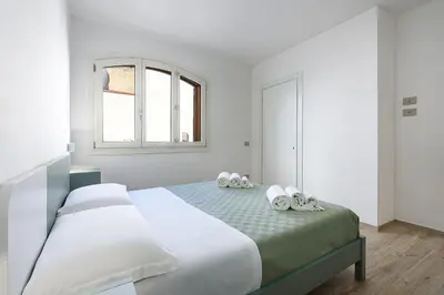 a white bedroom with a bed with a window at A Casa Di Vale in San Vito lo Capo