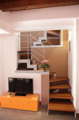 a living room with a staircase and a tv at Apartment Papyri in Palermo