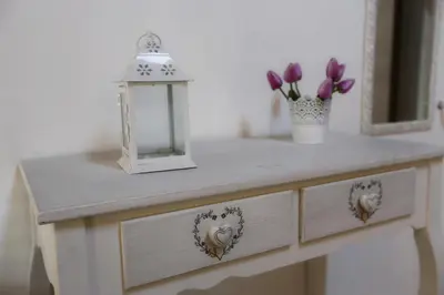 a dressing table with a lamp and flowers on it at Apartment Papyri in Palermo