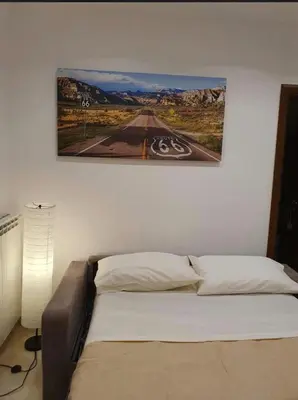 a bed in a bedroom with a painting on the wall at Calandreafamily, appartamento 2 camere da letto vicino al centro Palermo in Palermo