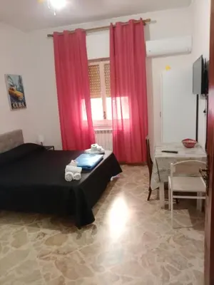 a bedroom with red curtains and a bed and a table at Framamired in Palermo