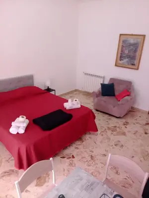 a bedroom with a red bed with two towel animals on it at Framamired in Palermo