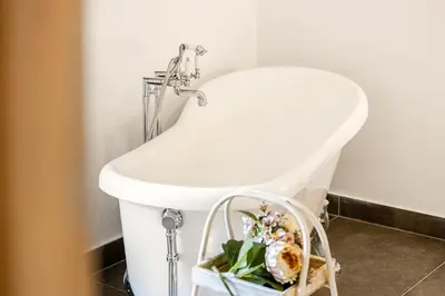 a white sink in a bathroom with a basket of flowers at Angelica holiday home in Palermo