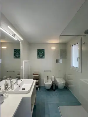 a white bathroom with two sinks and two toilets at Paradiso Isulidda in Macari