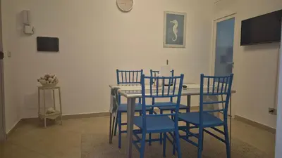 a dining room table with two blue chairs and a table at La Casuzza 3 al mare in Palermo