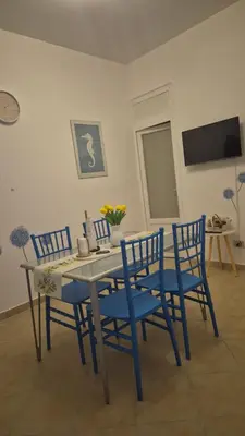 a dining room with a table and blue chairs at La Casuzza 3 al mare in Palermo