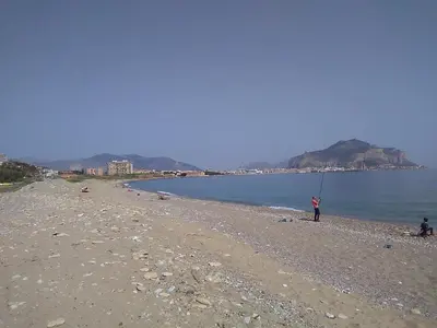a person standing on a beach with a kite at Domus in Palermo