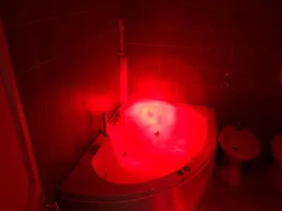 a red bath tub in a bathroom with a toilet at Alba Camere in Palermo