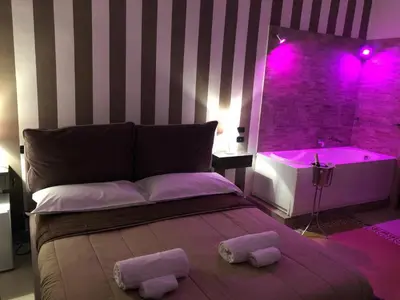 a bedroom with a bed and a tub with purple lights at Alba Camere in Palermo