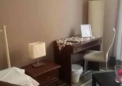 a bedroom with a desk with a lamp and a chair at Alba Camere in Palermo