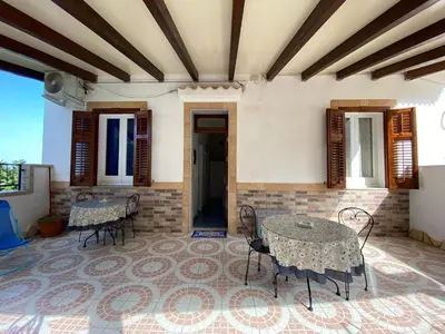 a patio with tables and chairs in a building at Appartamenti da Clarissa in Macari