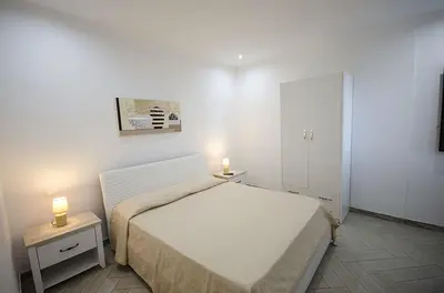 a bedroom with a bed and two lights on two tables at Appartamenti da Clarissa in Macari
