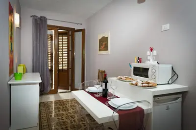 a kitchen with a microwave and a table with a plate of food at Via Nuova in Castellammare del Golfo