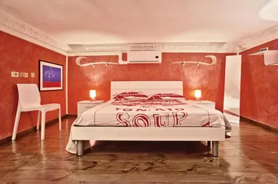 a bedroom with a bed and a table and a chair at Trilocale al Politeama - Zyz in Palermo
