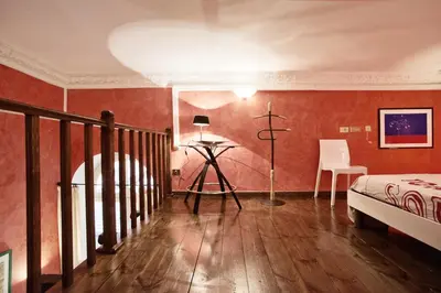 a bedroom with red walls and a bed and a table at Trilocale al Politeama - Zyz in Palermo