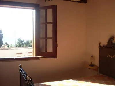 an empty room with a window and a bed and a bed sidx sidx at Baglio Fontana in Castelluzzo