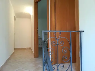 a hallway with a door and a stair railing at Casa Eva in Castelluzzo