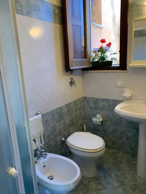 a bathroom with a toilet and a sink and a window at Casa Eva in Castelluzzo