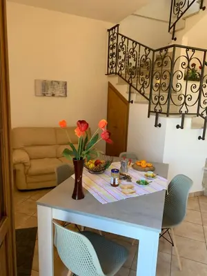 a dining room table with a vase of flowers on it at Casa Eva in Castelluzzo