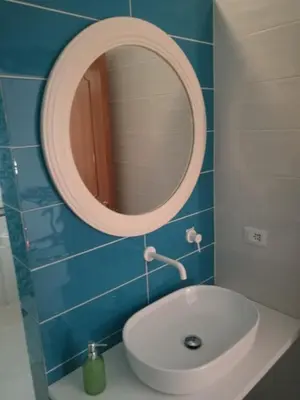 a bathroom with a white sink and a mirror at Villa Agave - SeaFront - Pool Kids - BBQ in Santa Flavia
