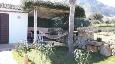 a patio with a hammock in a garden at Villetta Degli Oleandri in Castellammare del Golfo