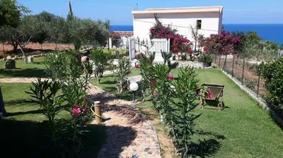 a garden with pink flowers and a fence at Villetta Degli Oleandri in Castellammare del Golfo
