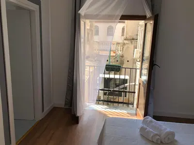 a room with a bed and a view of a balcony at Cialoma B&B in Palermo